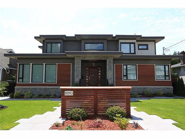 Front yard landscaping in Richmond, British Columbia with concrete pavers, manicured lawn, oriental-style plants, and a custom house sign.