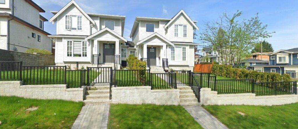 Front yard in North Vancouver featuring a custom concrete retaining wall with aluminum fence.