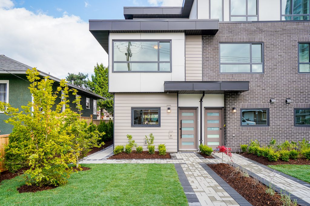 Walkway in Richmond for a multifamily property with custom shrubs planted in mulch along the side.